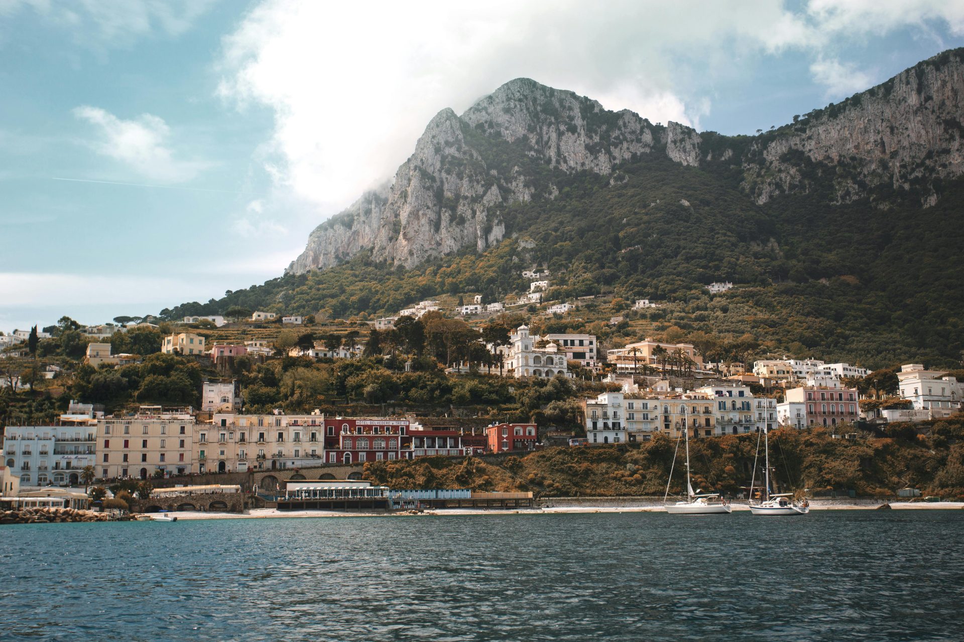 Impresionante fotografía de la ciudad costera de la isla de Capri con montañas y mar.